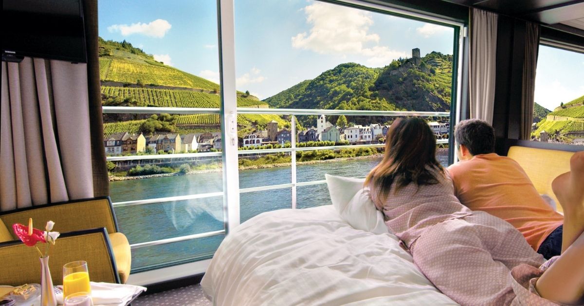 Avalon Waterways Panorama Suite interior view with 11 feet wall-to-wall window and bed facing the river view
