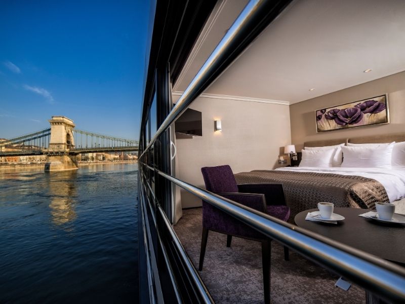 Avalon Waterways Panorama Suite interior view with 11 feet wall-to-wall window and bed facing the river view